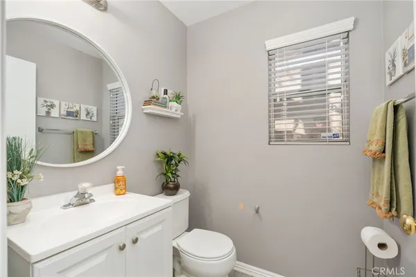 a bathroom with a sink vanity mirror and toilet