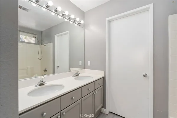 a bathroom with a double vanity sink and a mirror