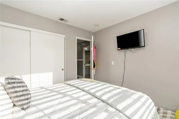 a bedroom with a bed and a flat screen tv