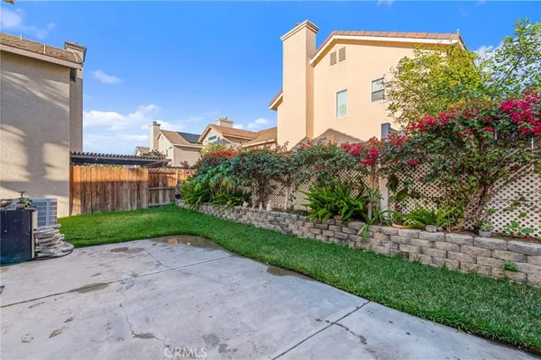 a front view of a house with a yard and a tree