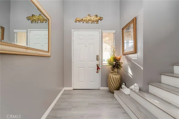 a view of a hallway with wooden floor and a potted plant