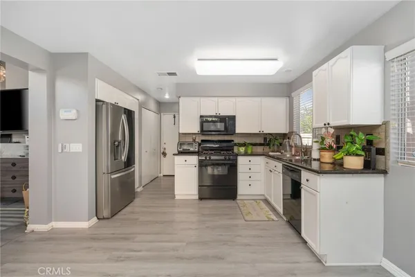 a kitchen with stainless steel appliances granite countertop a refrigerator and a stove top oven