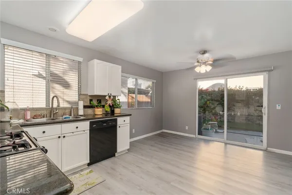 a kitchen with granite countertop a stove top oven sink and cabinets