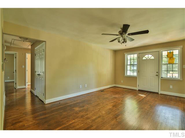 711 Tyler Road Raleigh, NC 27604 - Photo 8 of 24 a view of an empty room with window and wooden floor