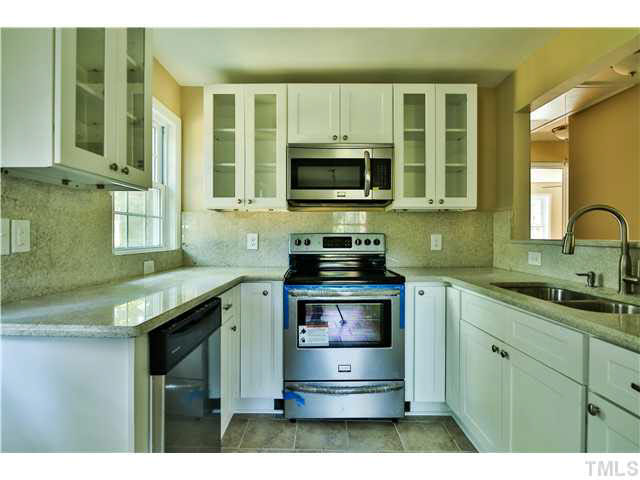 711 Tyler Road Raleigh, NC 27604 - Photo 9 of 24 a kitchen with stainless steel appliances granite countertop a stove and a microwave