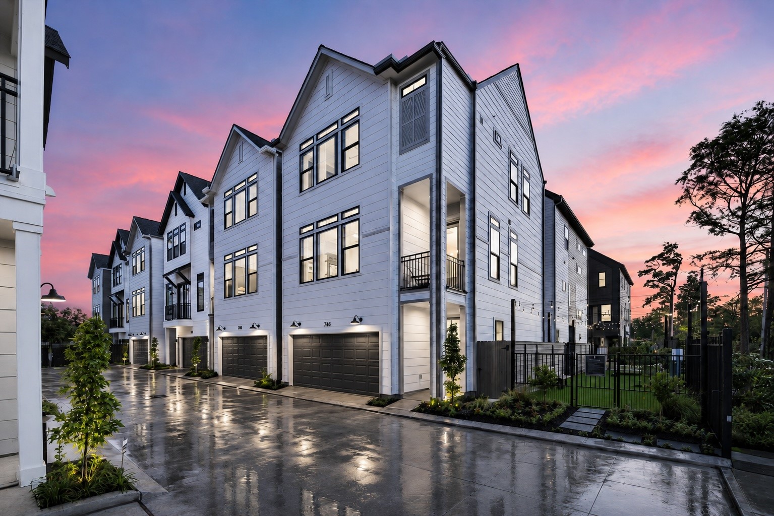 752 Curtin Street Houston, TX 77018 - Photo 34 of 37 Modern townhomes with sleek white exteriors line a clean, well-lit street, set against a stunning sunset sky.