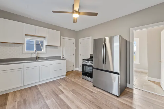 a kitchen with a refrigerator cabinets and wooden floor