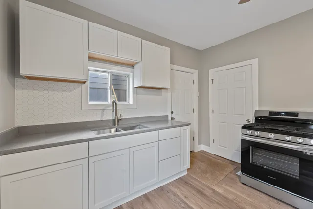 a kitchen with granite countertop a sink stainless steel appliances and cabinets
