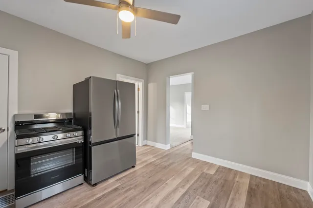 a kitchen with a refrigerator and a stove top oven
