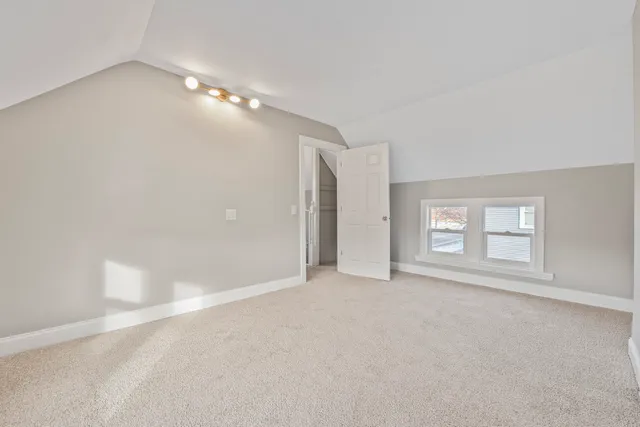a view of empty room with window and ceiling fan