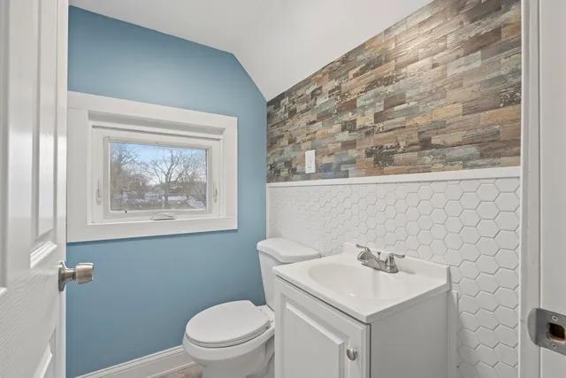 a bathroom with a sink a toilet and mirror