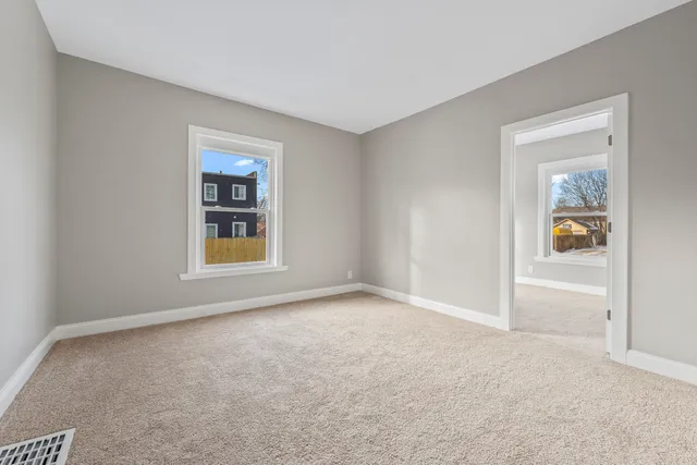 an empty room with windows and closet