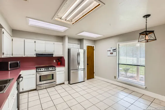 a kitchen with white cabinets appliances and sink