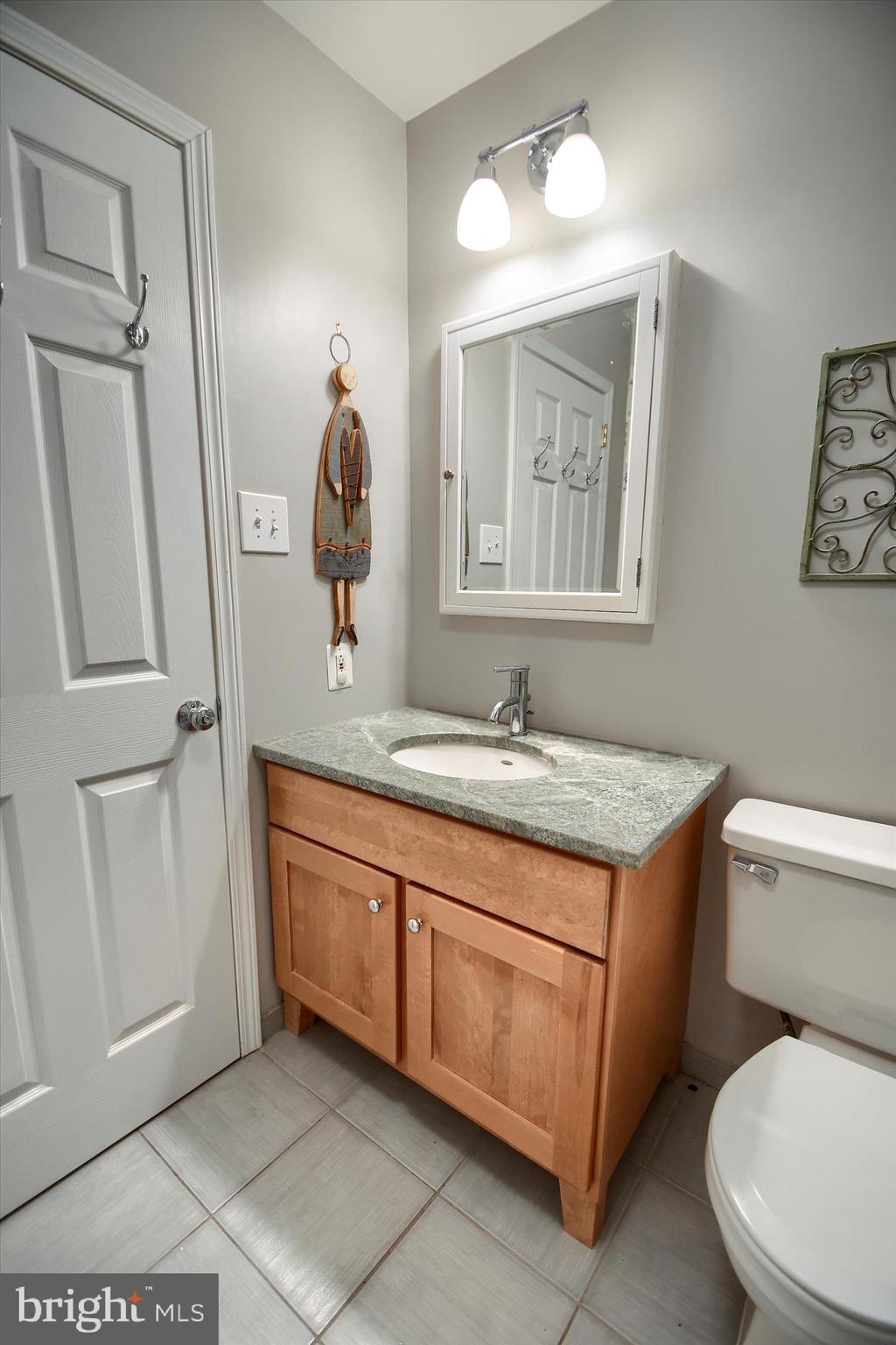 1304 Weatherstone Drive, Unit 1304 Paoli, PA 19301 - Photo 25 of 35 a bathroom with a granite countertop toilet sink and mirror