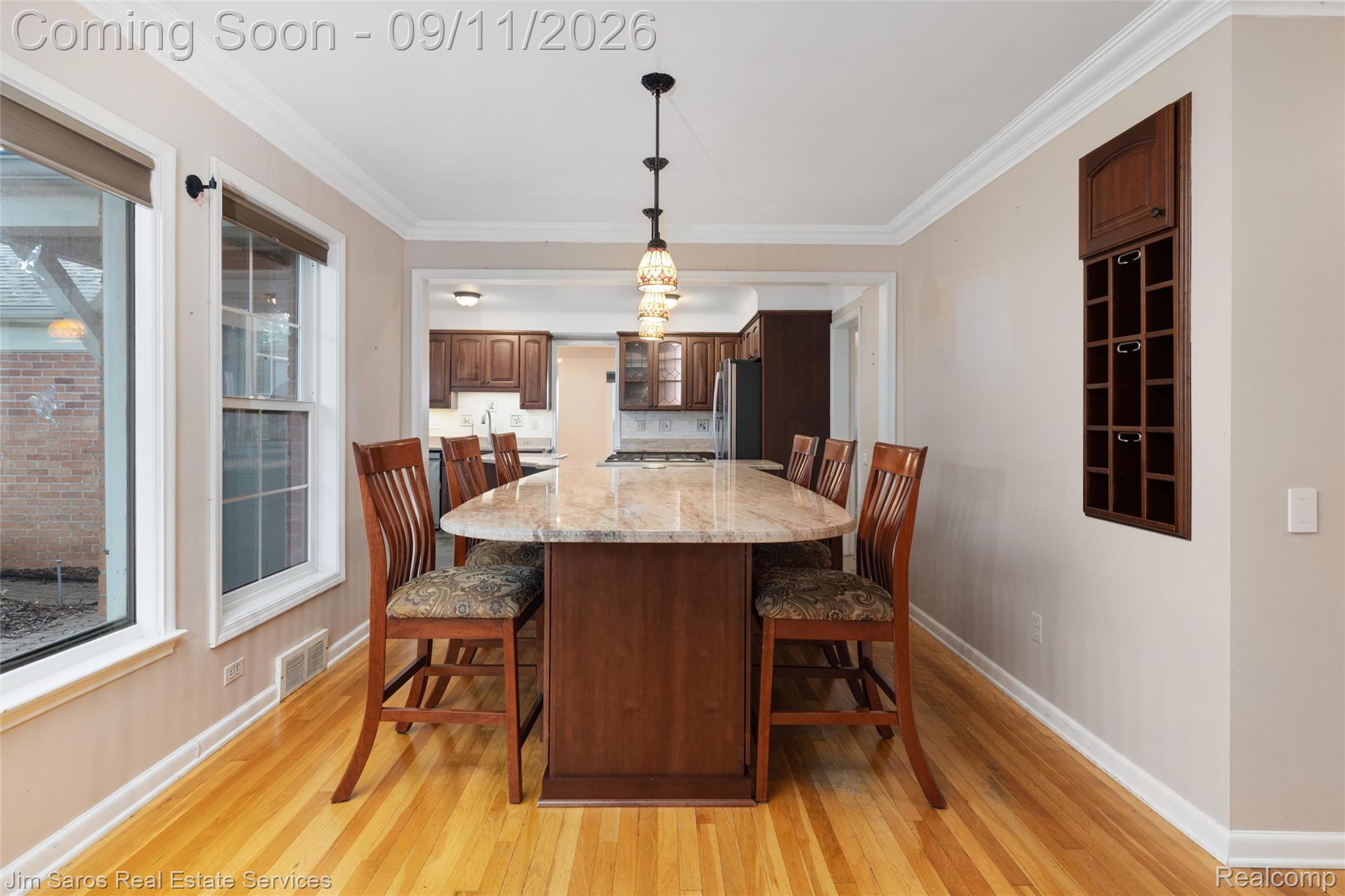 1445 Devonshire Road Grosse Pointe, MI 48230 - Photo 7 of 30 Hardwood flooring, crown molding, built-in wine rack, stone countertop island, and pendant lighting