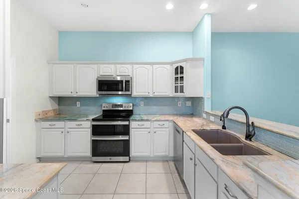 a kitchen with stainless steel appliances granite countertop a sink and a stove top oven