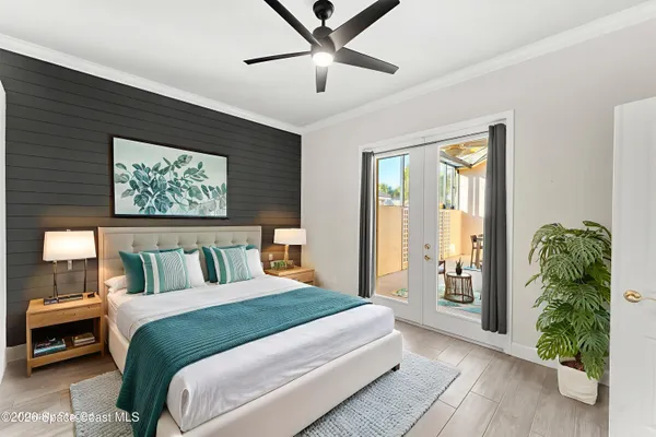 a bedroom with a large bed and a chandelier