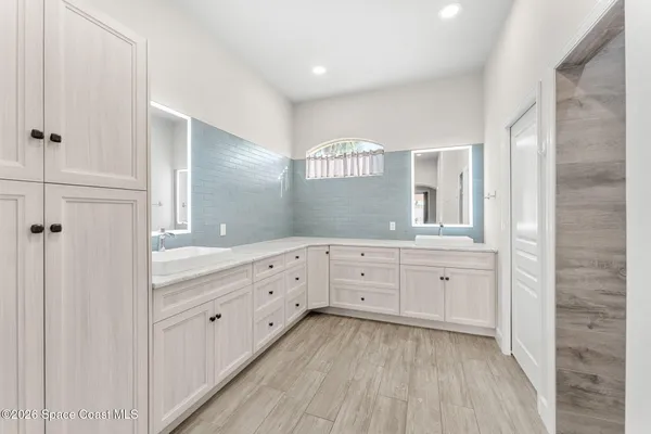 a spacious bathroom with double vanity and a mirror