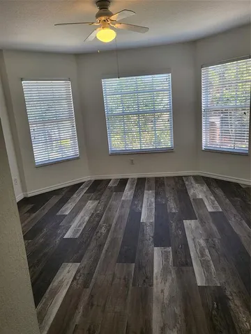 a view of empty room with wooden floor and window