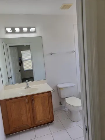a bathroom with a granite countertop sink a toilet and mirror
