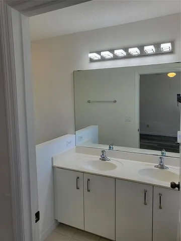 a bathroom with a sink vanity and mirror