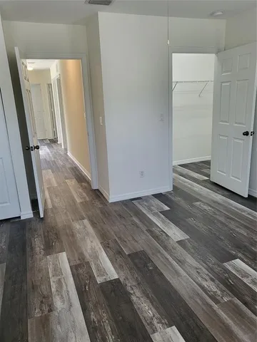 a view of a closet area with hardwood floor