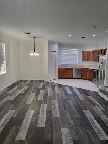 a view of empty room with wooden floor and window