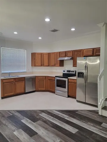 a kitchen with stainless steel appliances wooden cabinets a sink and a stove