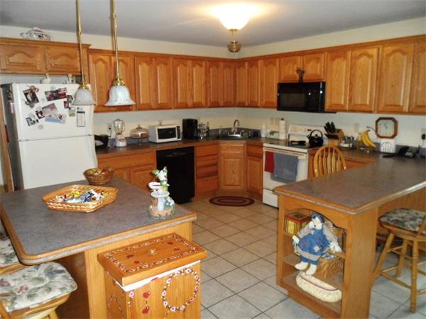 491 Petersham Road Athol, MA 01331 - Photo 3 of 22 a kitchen with stainless steel appliances granite countertop a stove a sink dishwasher and a microwave with wooden cabinets