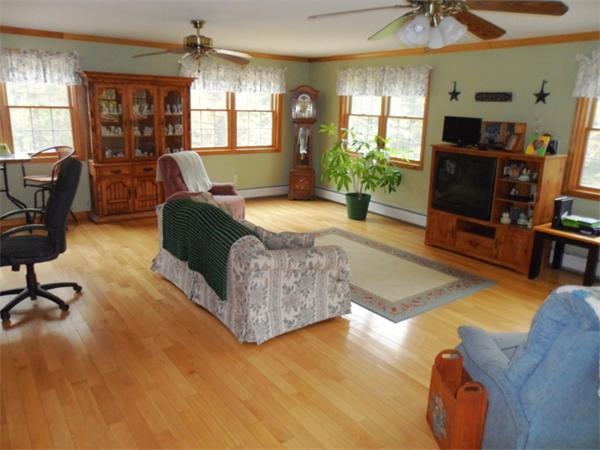 491 Petersham Road Athol, MA 01331 - Photo 9 of 22 a spacious bedroom with a bed a couch and a chandelier