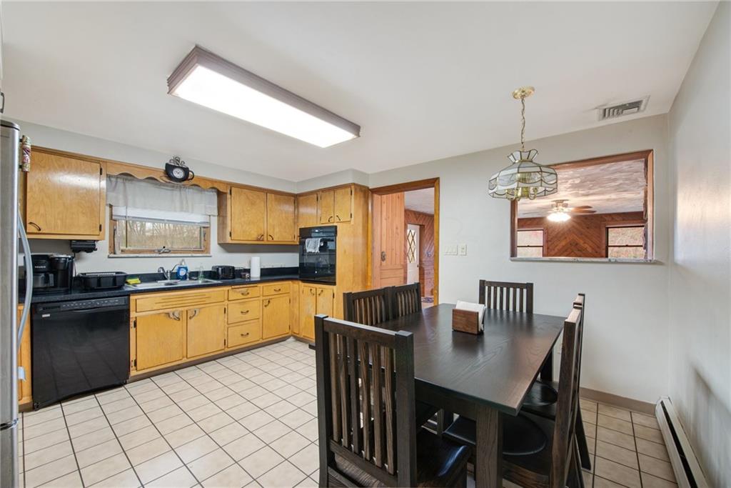 221 Story Road Export, PA 15632 - Photo 18 of 30 a kitchen with stainless steel appliances granite countertop a kitchen island a stove a dining table and chairs with wooden floor