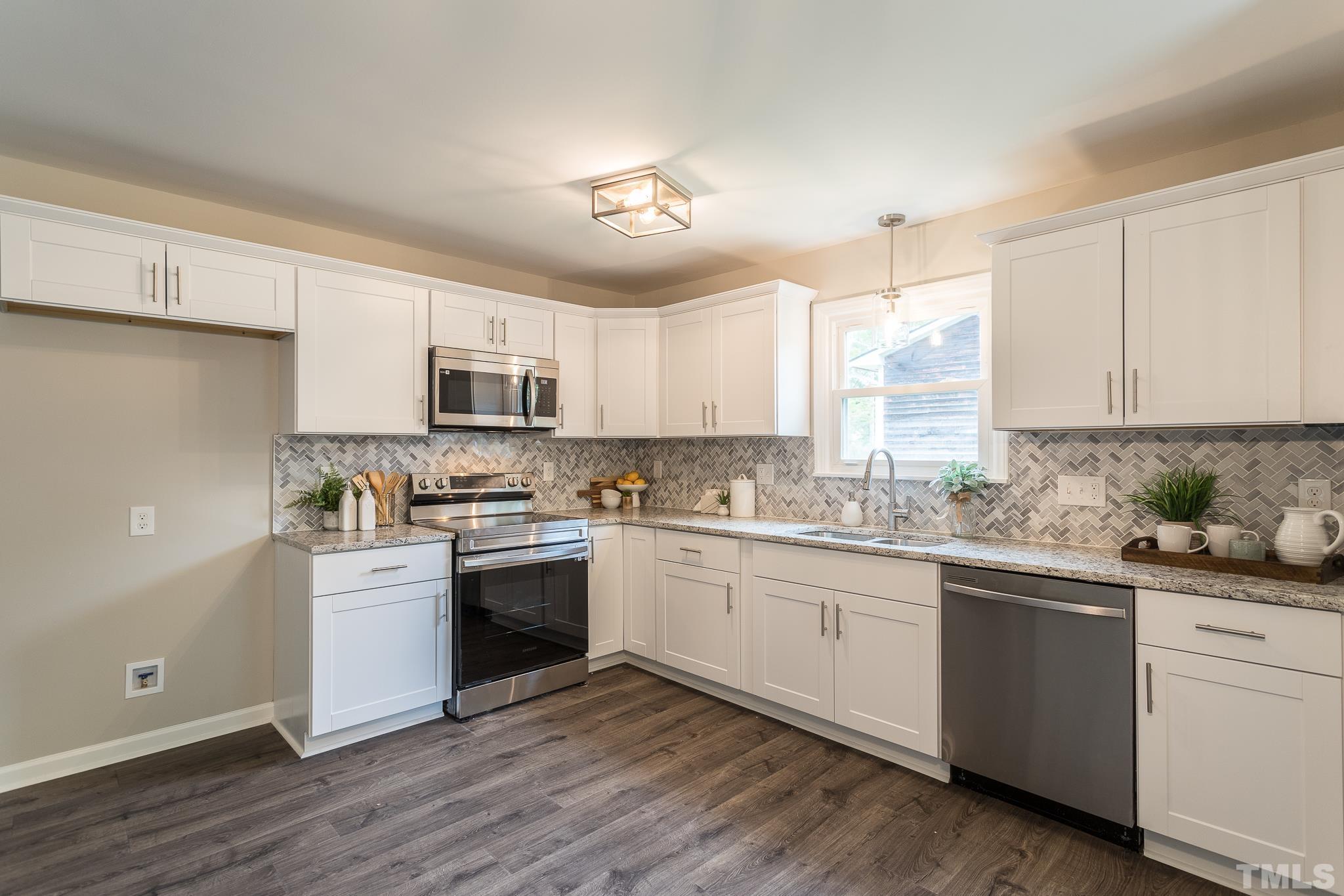 4000 Wheaton Road Durham, NC 27704 - Photo 2 of 21 a kitchen with granite countertop white cabinets and white appliances