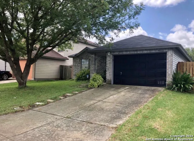 a front view of a house with a garden and trees