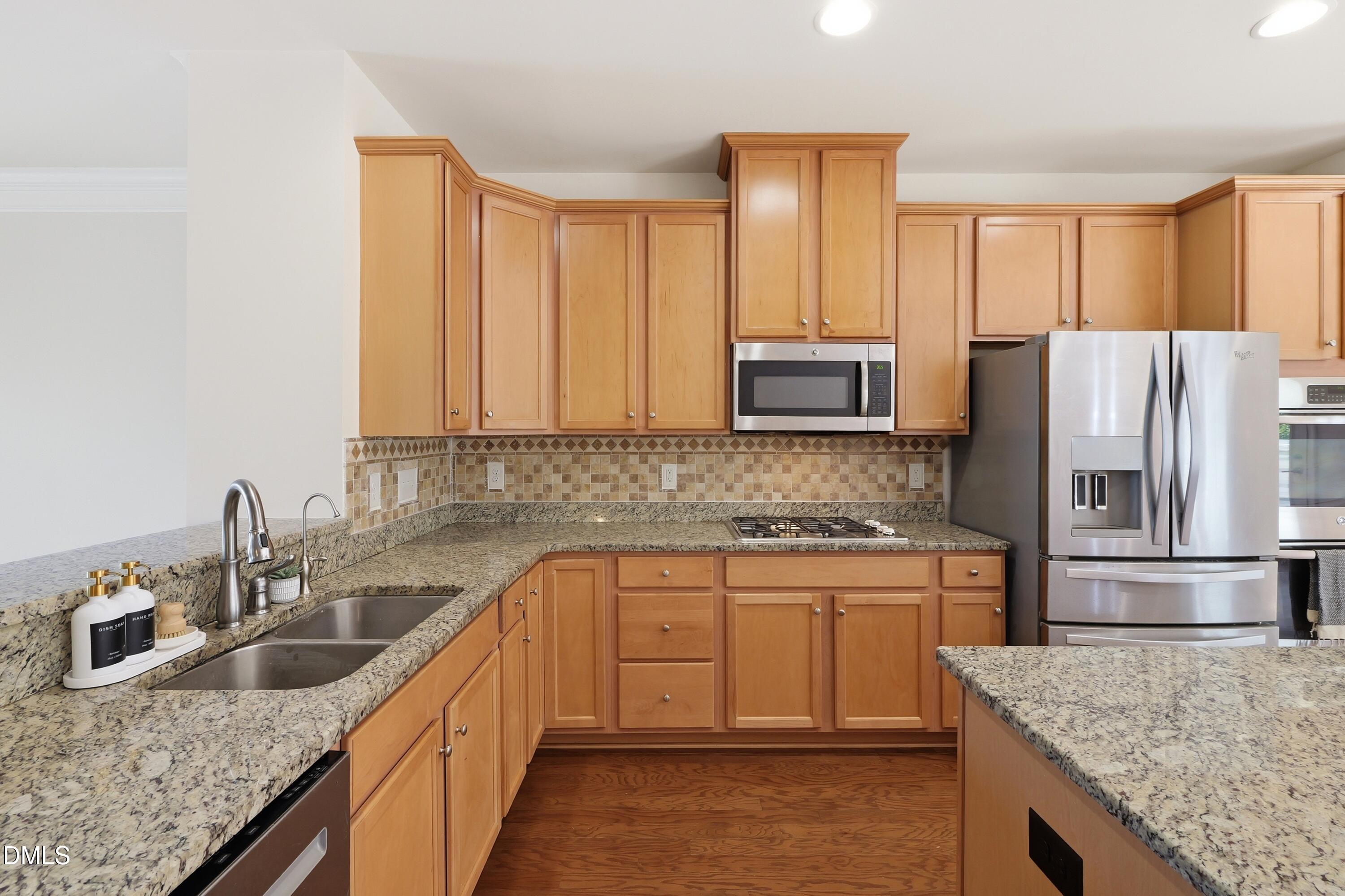 1004 Waymaker Court Apex, NC 27502 - Photo 7 of 30 a kitchen with stainless steel appliances granite countertop a sink stove and refrigerator