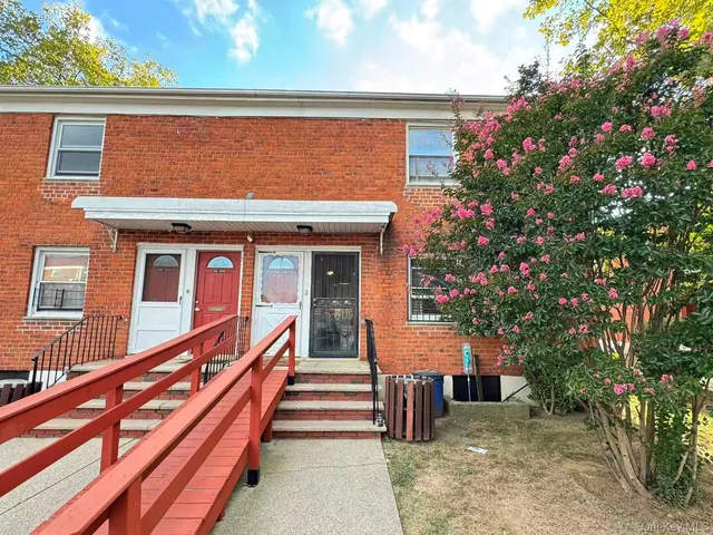 a view of a house with a large windows and flower plants