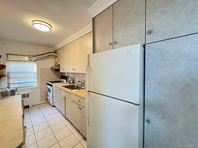 a kitchen with a refrigerator a stove top oven and cabinets