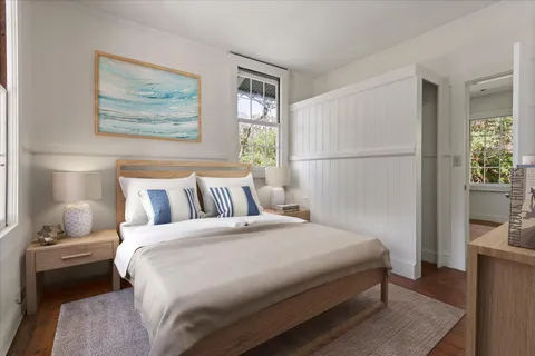 a bedroom with a bed and a painting on the wall