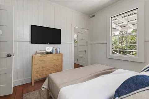 a bedroom with a bed and a flat screen tv