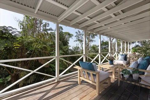 a view of a balcony with chairs and wooden floor