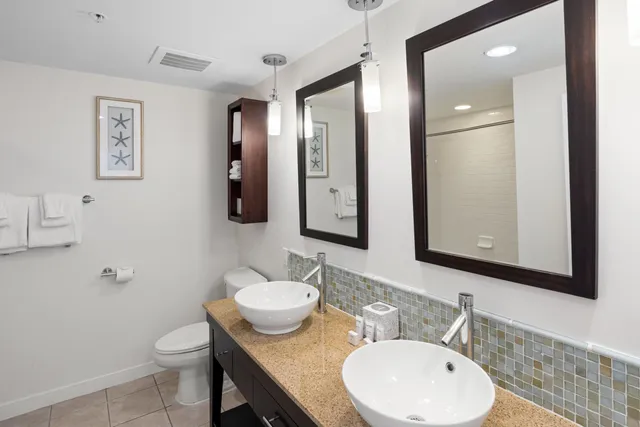 a bathroom with a granite countertop sink toilet and mirror