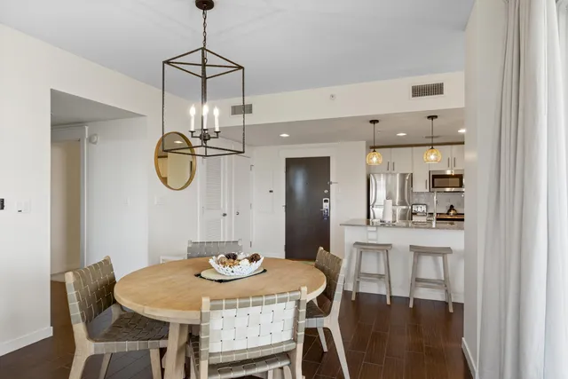 a view of a dining room with furniture a chandelier and wooden floor
