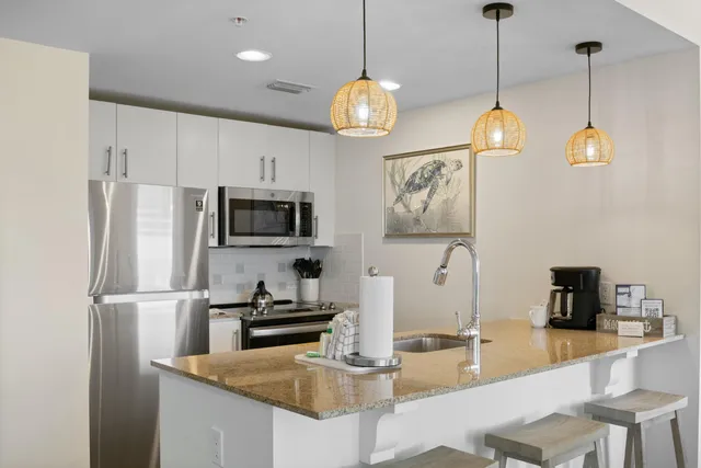 a kitchen with stainless steel appliances granite countertop a sink refrigerator and microwave