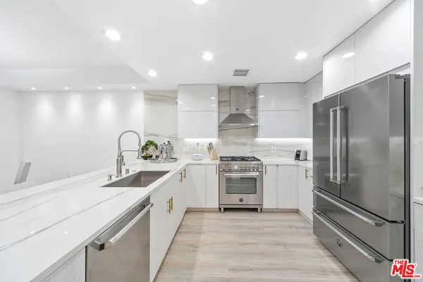 a kitchen with stainless steel appliances a refrigerator sink and stove