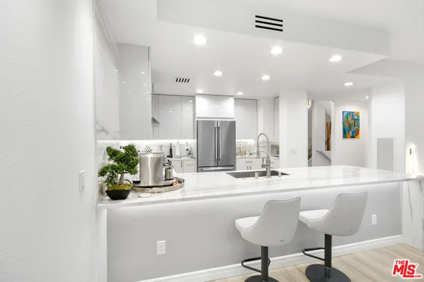 a kitchen with kitchen island stainless steel appliances a sink and cabinets