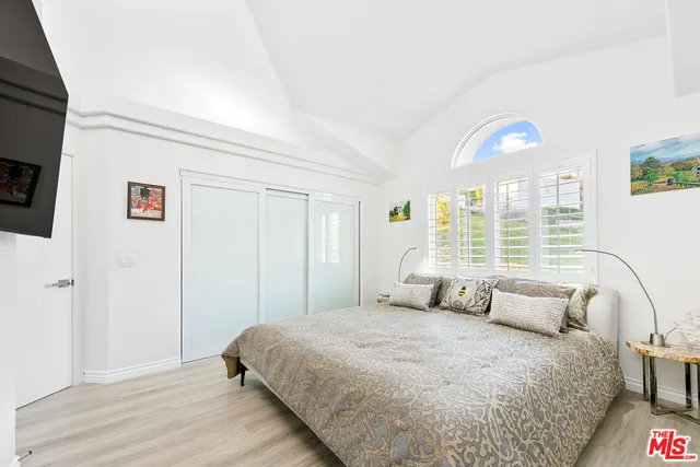 a bedroom with a bed and a large window