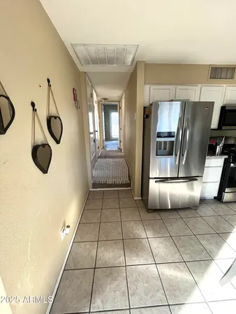 a kitchen with a refrigerator a stove top oven and cabinets