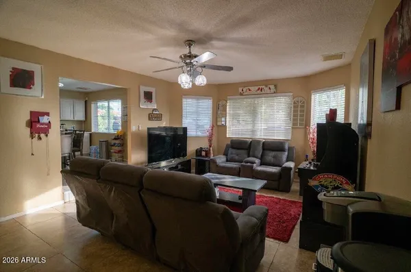 a living room with furniture a ceiling fan and a window