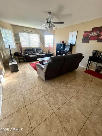 a living room with furniture and a gym machine next to a window