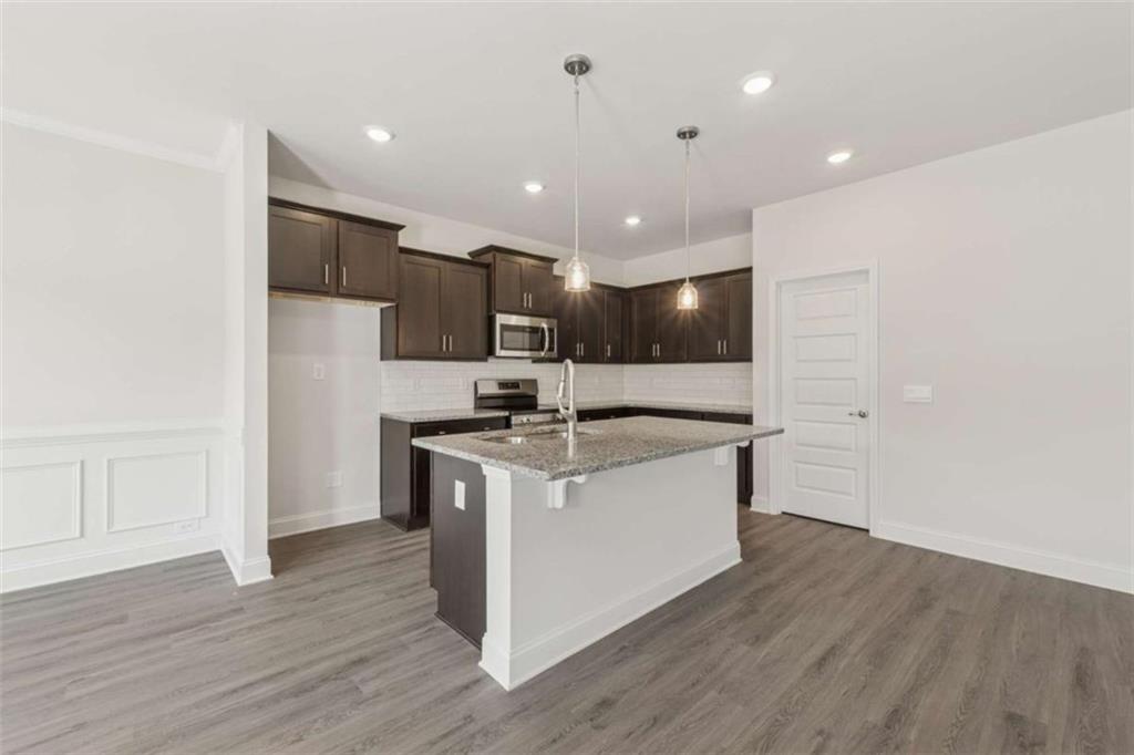 263 Eason Street Bowdon, GA 30108 - Photo 3 of 11 a large kitchen with stainless steel appliances granite countertop a white stove top oven and white cabinets