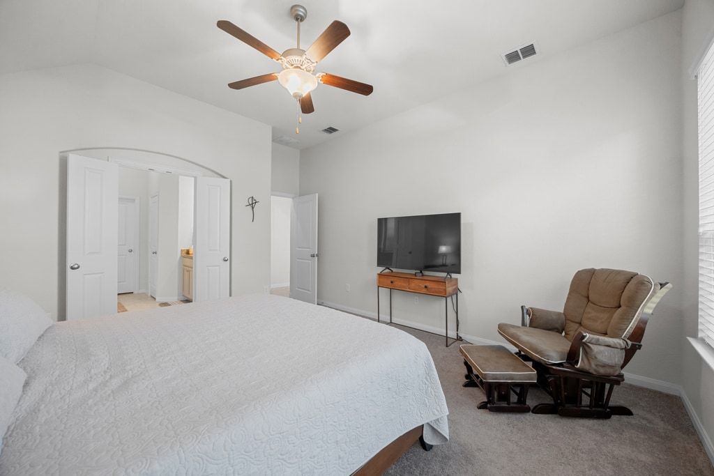 606 Linares Lane Austin, TX 78748 - Photo 21 of 35 Bedroom featuring light carpet, a ceiling fan, vaulted ceiling, and ensuite bathroom